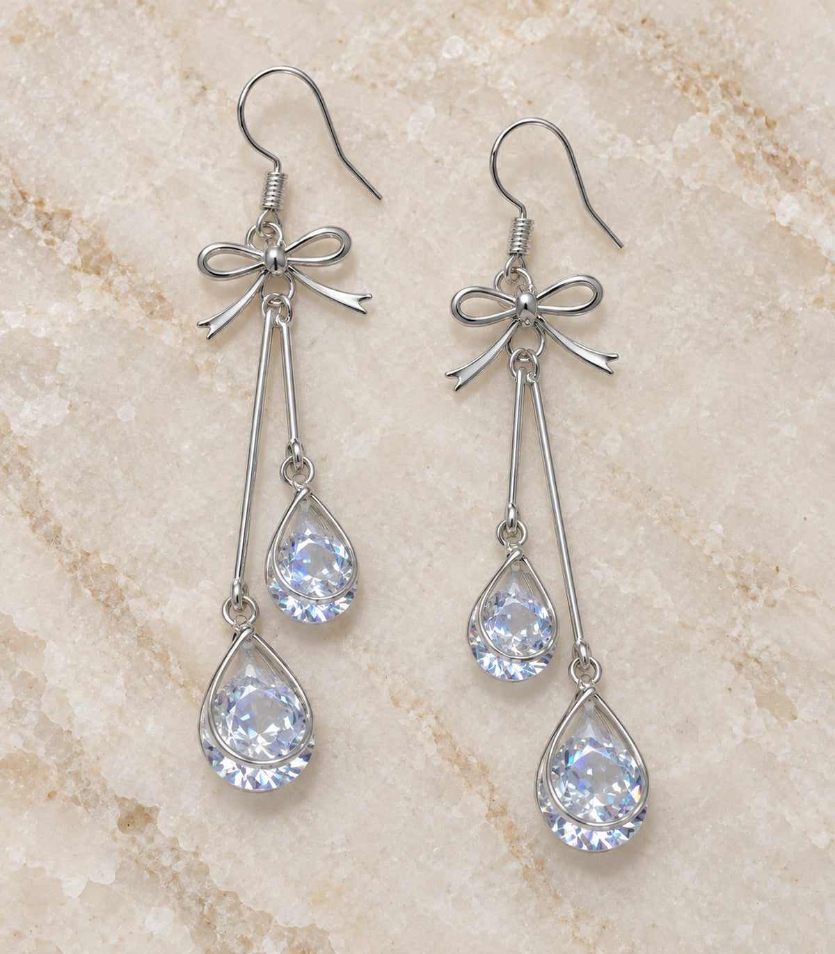 JIMIKI Silver Tone Bow Twin Pear Wire Drop Earring Pair in Silver-tone, editorial flat lay