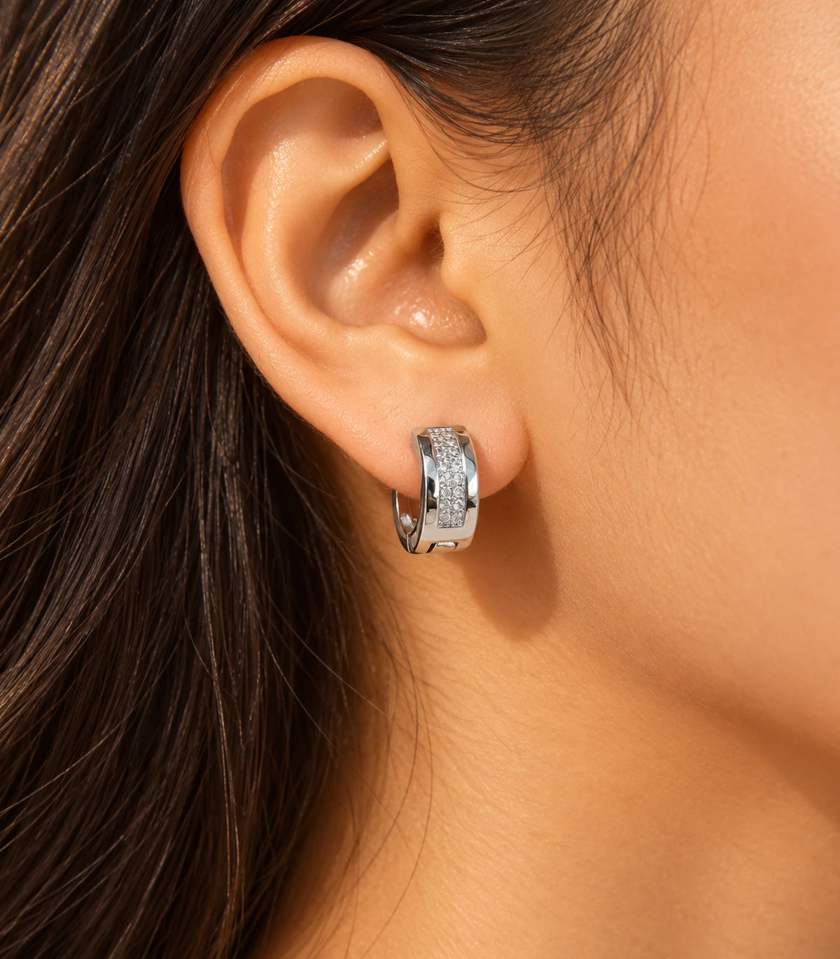 JIMIKI Silver central pave strip huggie hoop earrings, worn in warm light #color_silver
