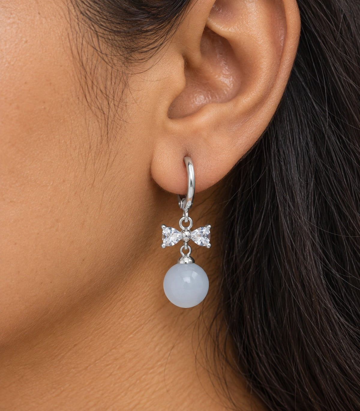 JIMIKI Silver-Tone Clear Crystal Bow Pale Blue Bead-Drop Huggie Earrings in Silver / Clear / Pale Blue, close-up detail