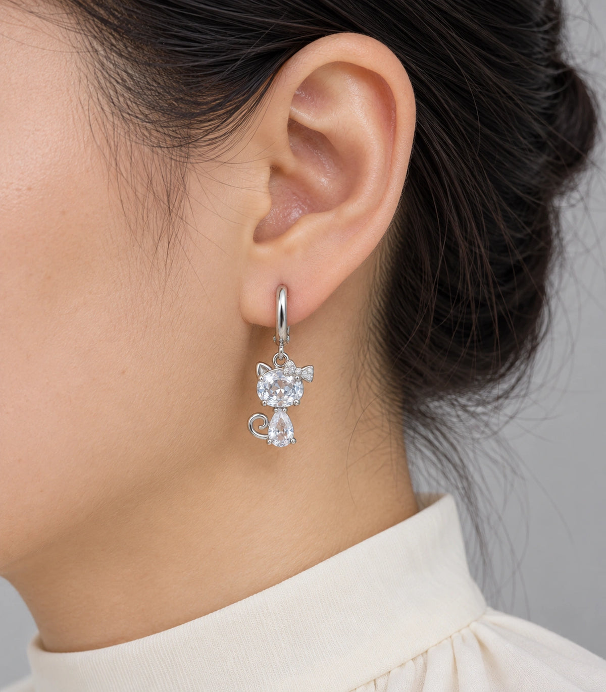 JIMIKI Silver Tone Clear Crystal Cat Bow Hoop Earring Pair in Silver tone / clear, model wearing view