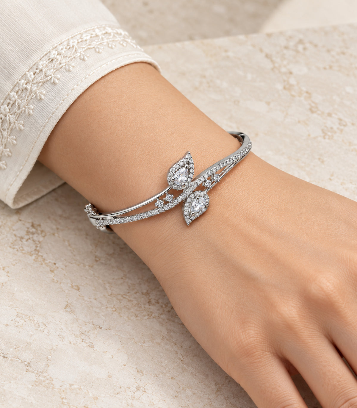 Silver-tone clear double leaf bangle worn on a wrist