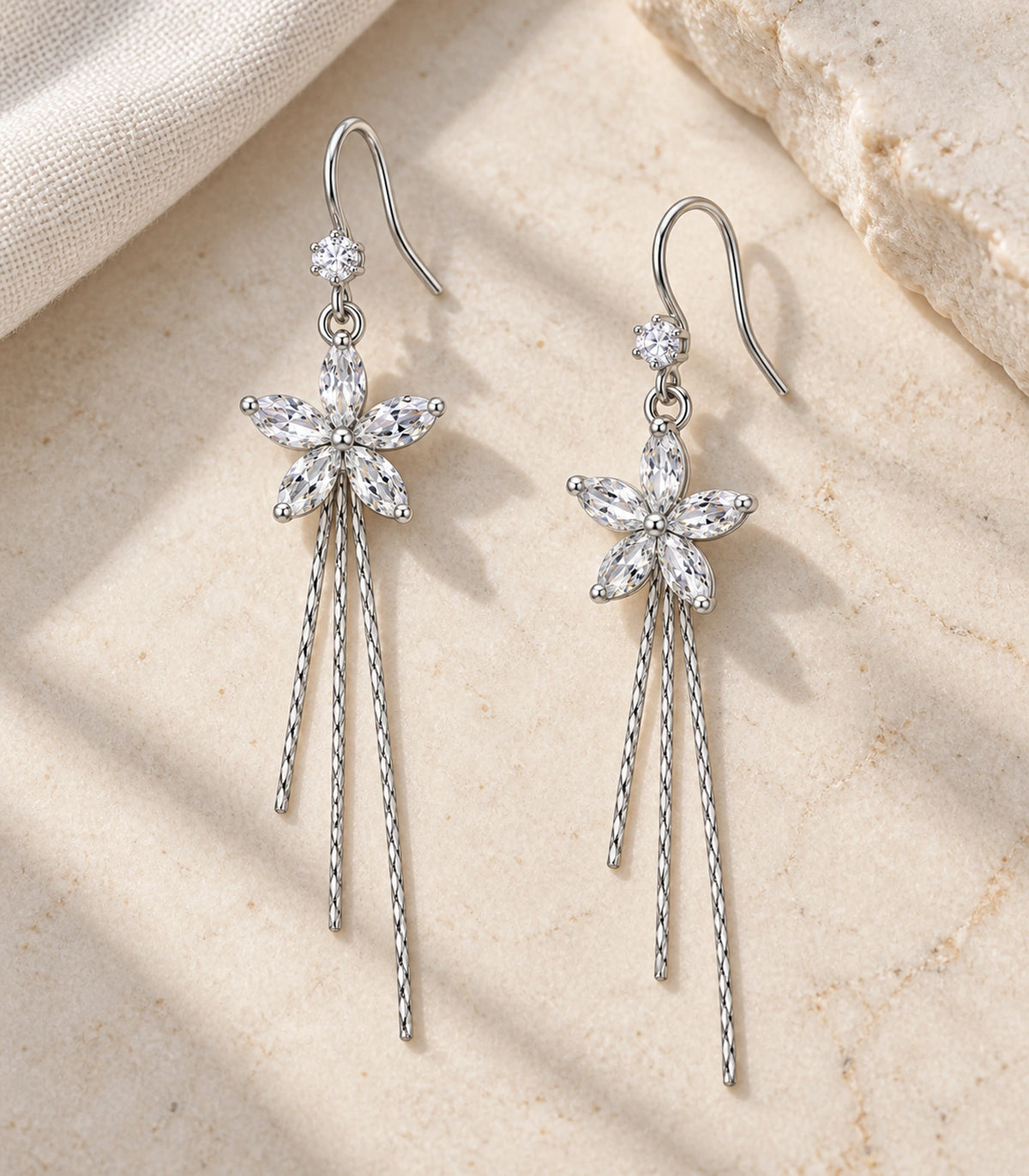 JIMIKI Silver Tone Clear Five Petal Flower Chain Tassel Earring Pair in Silver tone / clear, editorial flat lay