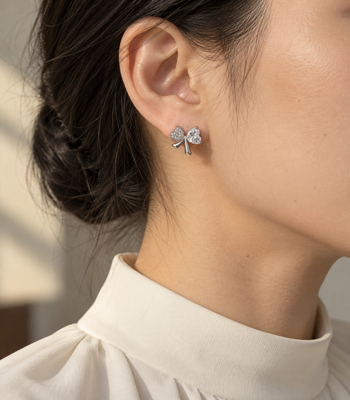 JIMIKI Silver Tone Clear Heart Bow Stud Earring Pair in Silver tone, editorial model view