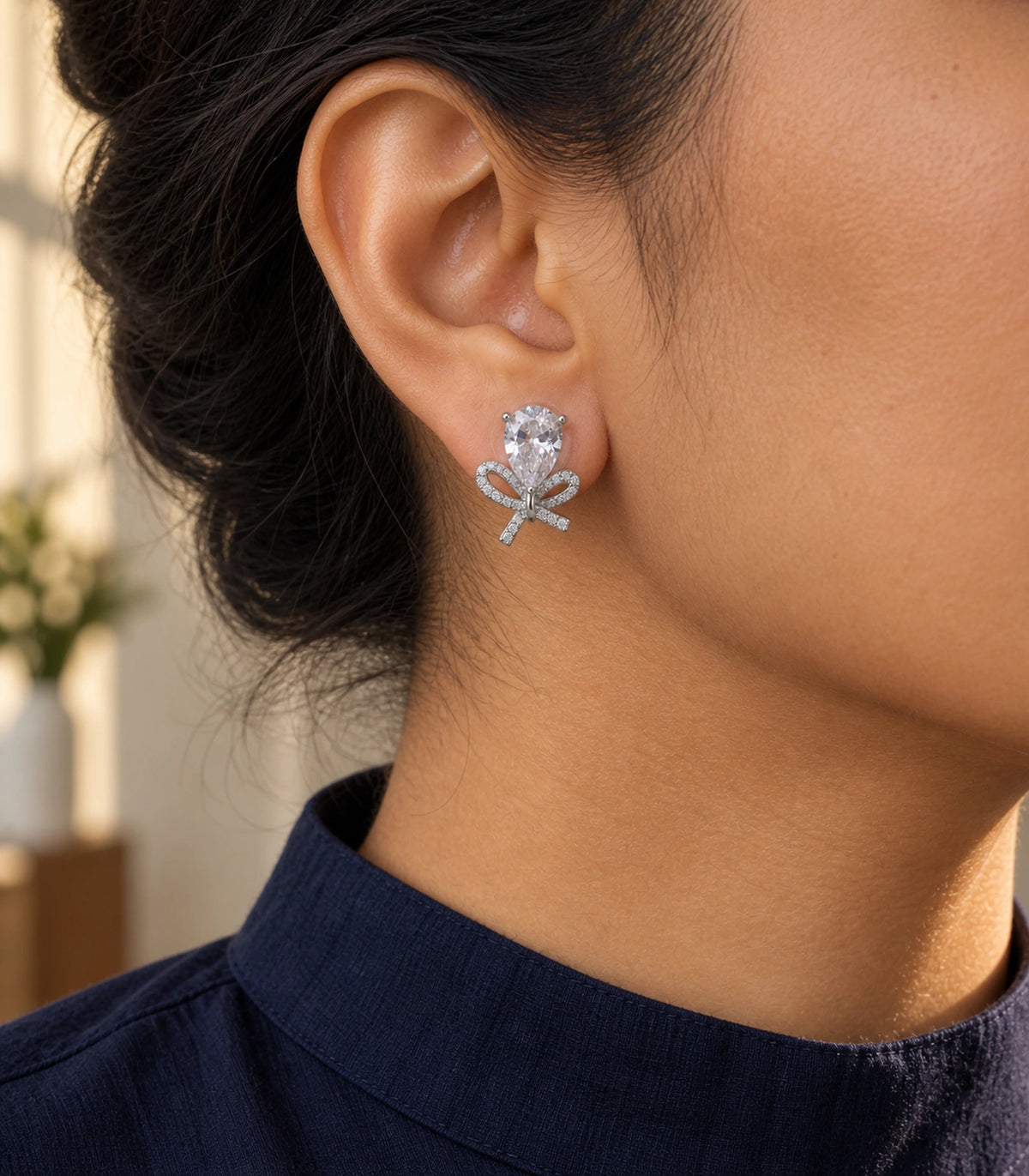 JIMIKI Silver Tone Clear Pear Crystal Bow Stud Earring Pair in Silver-tone, editorial model view