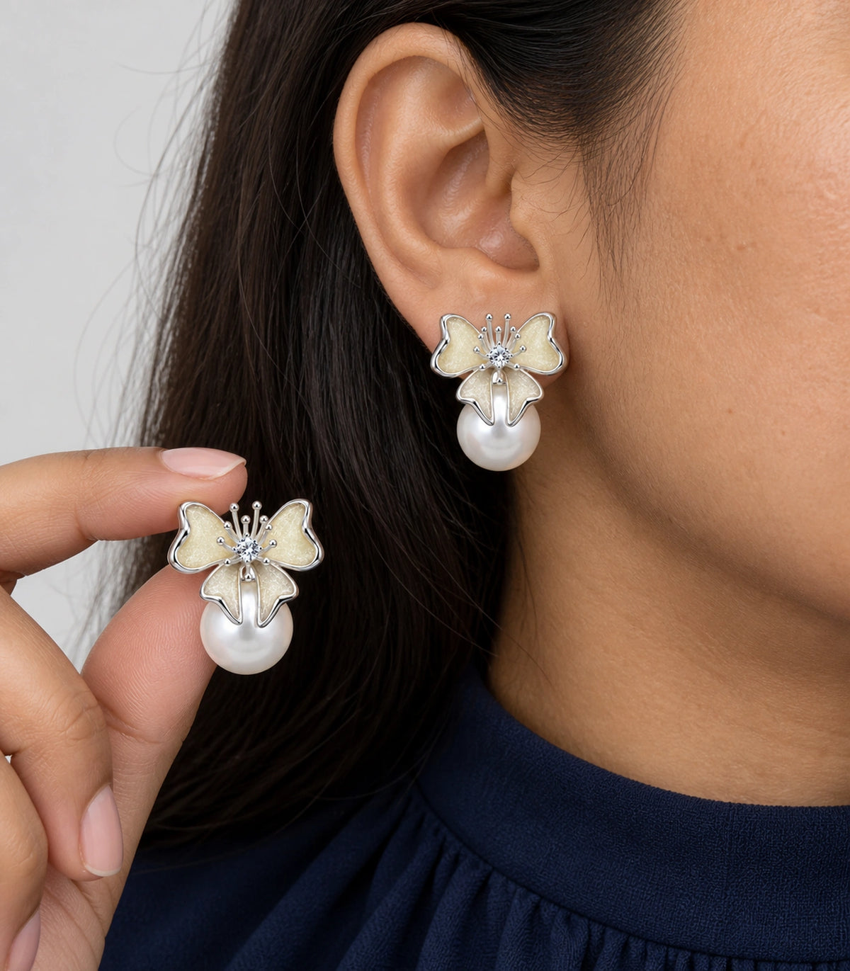 JIMIKI Butterfly Pearl Stud Earring Pair in Silver Tone / Cream, close-up detail #color_silver tone / cream