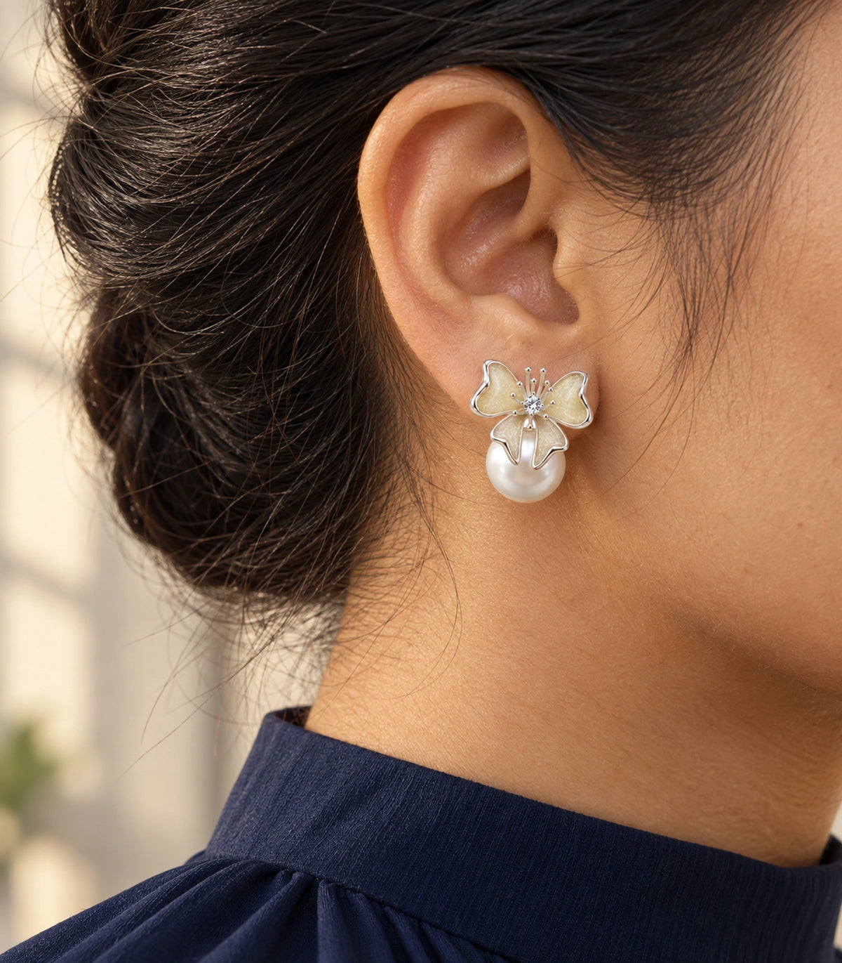 JIMIKI Butterfly Pearl Stud Earring Pair in Silver Tone / Cream, editorial model view #color_silver tone / cream