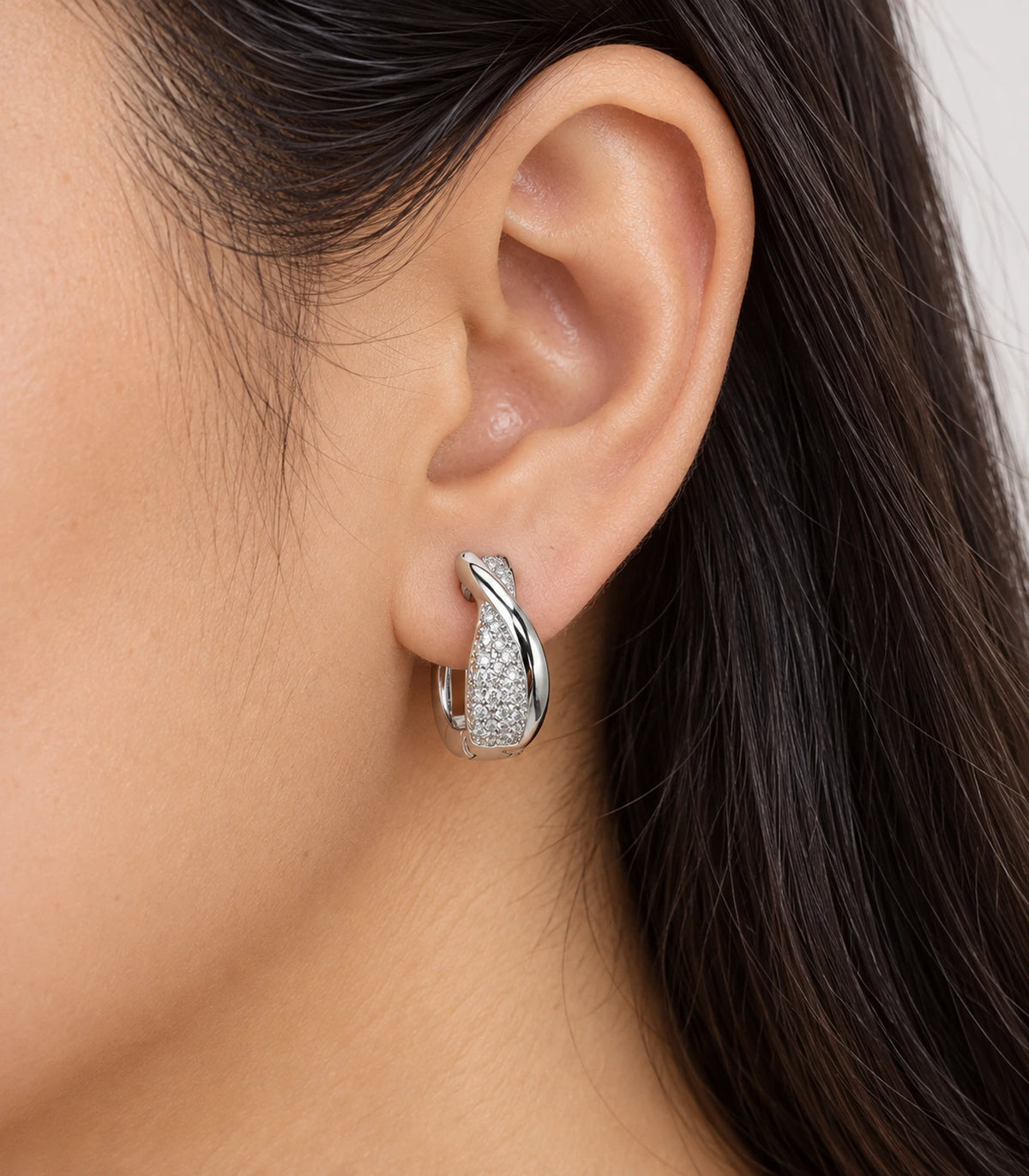 JIMIKI Silver crossover pave huggie hoop earrings, worn on the ear #color_silver