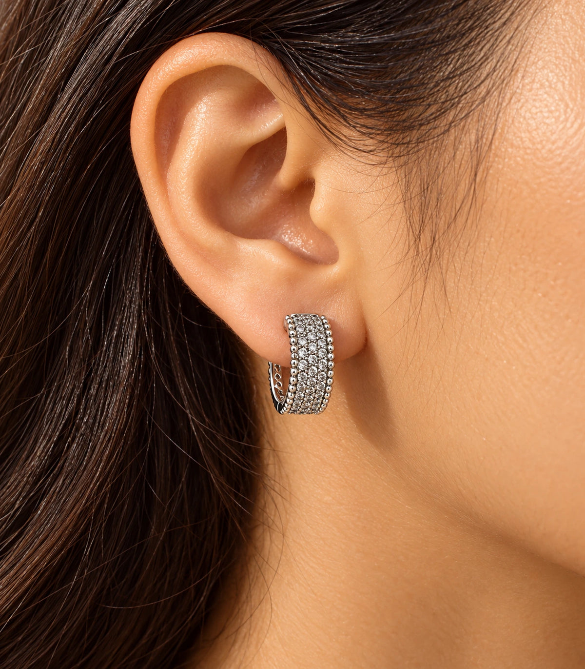 JIMIKI Silver Crystal Bead Border Huggie Hoop Earrings, worn in warm editorial lighting #color_silver