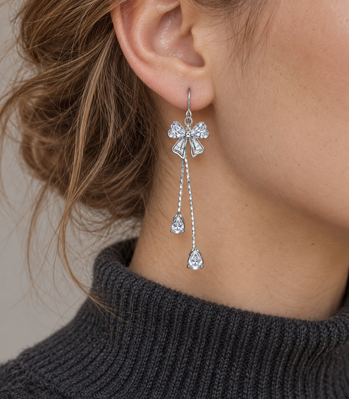 JIMIKI Silver-Tone Crystal Bow Twin Pear Drop Earrings in Silver Tone, editorial model view