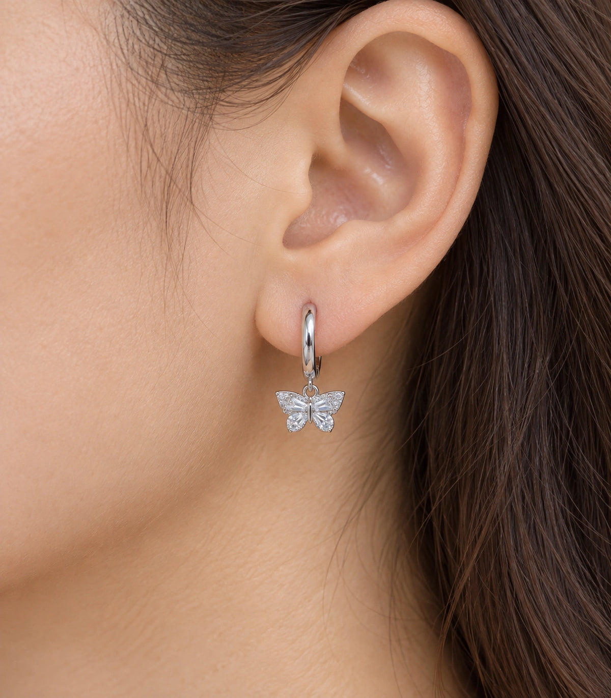 JIMIKI Crystal Butterfly Huggie Earrings in Silver / Clear, close-up detail #color_silver / clear