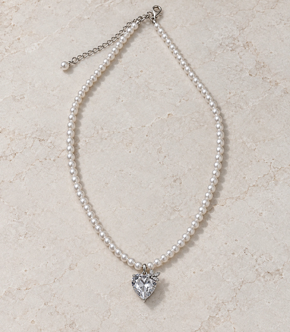 JIMIKI Silver-Tone Crystal Heart Pearl Necklace in Silver-tone / clear / white, arranged in an editorial flat lay