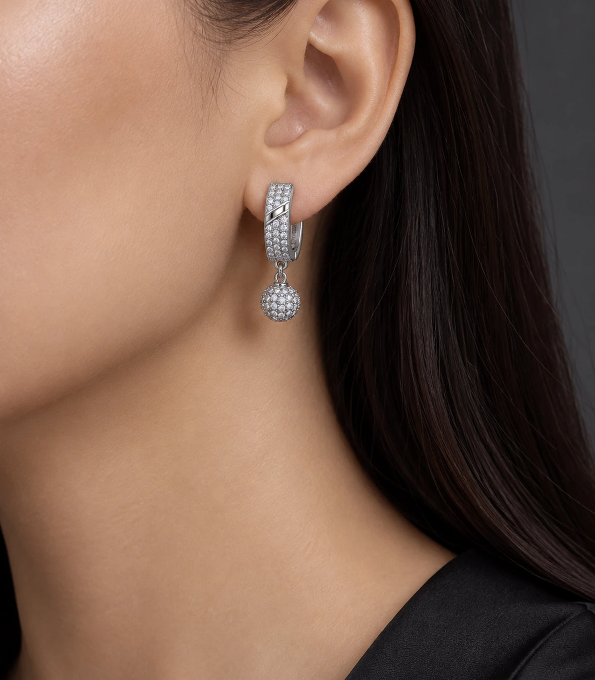 JIMIKI Silver-Tone Diagonal Pavé Ball Drop Huggie Earrings — earrings styled with an outfit #color_silver-tone / clear