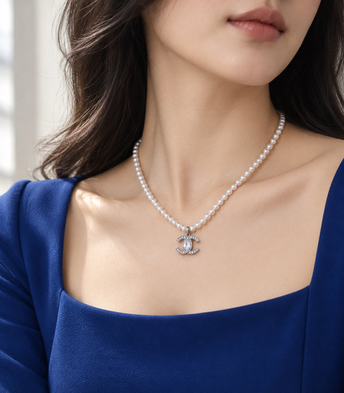 JIMIKI Silver-Tone Double-C Crystal Pearl Necklace in Silver-tone / clear / white, styled on a model in an editorial setting