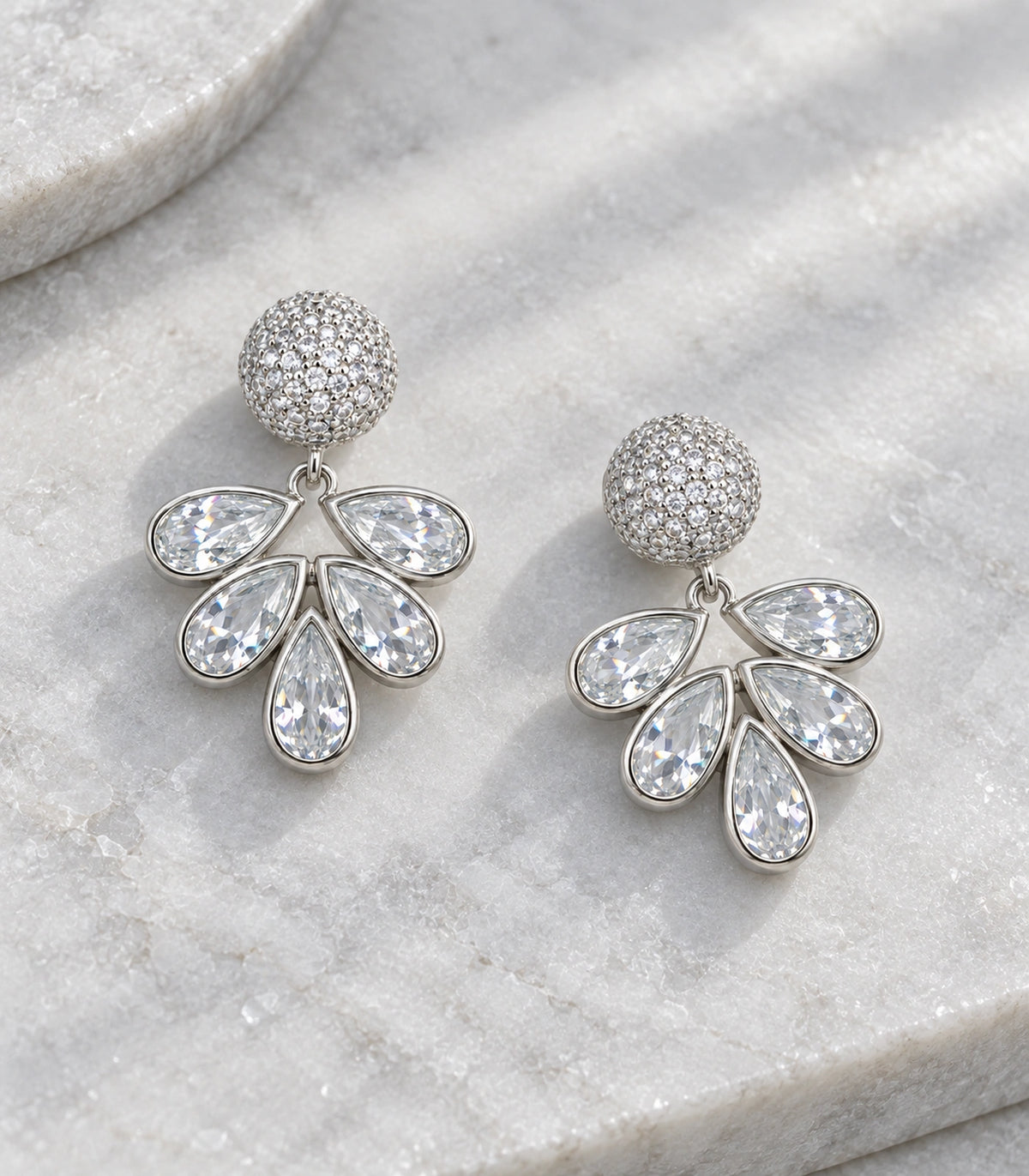 JIMIKI Silver-Tone Five-Teardrop Crystal Fan Drop Earrings in Silver Tone, editorial flat lay