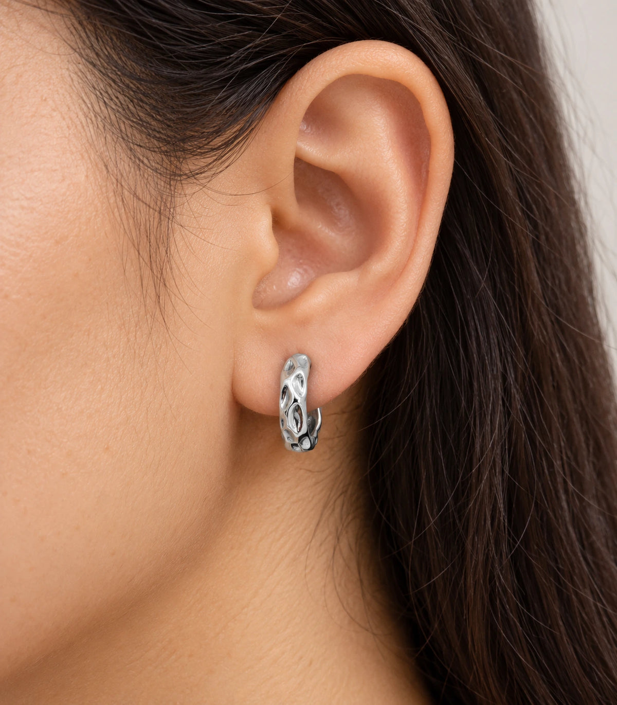 JIMIKI Silver Hammered Marquise Cutout Huggie Hoop Earrings, shown worn on the ear #color_silver