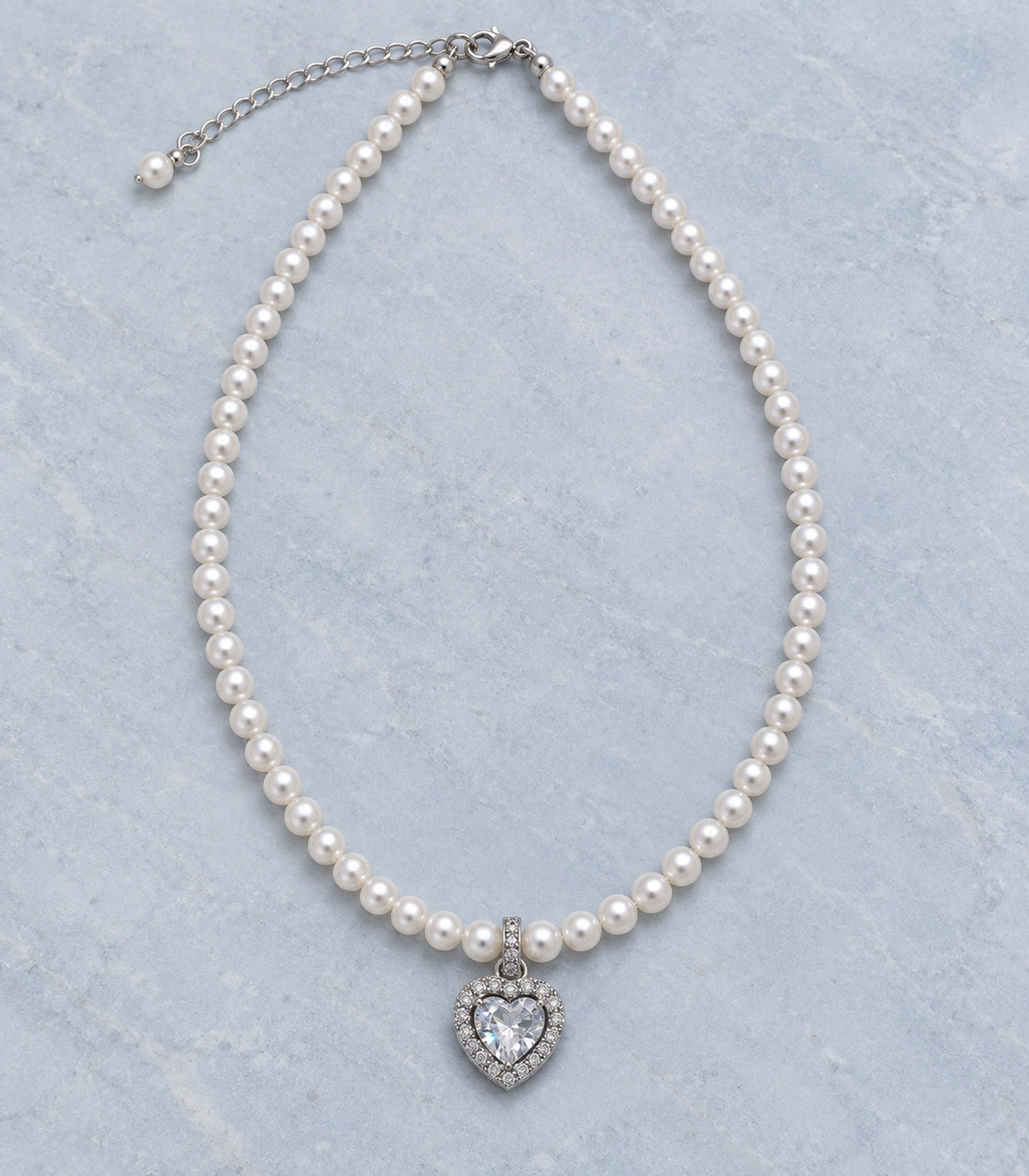 JIMIKI Silver Tone Heart Halo Crystal Pearl Style Necklace in Silver / White, editorial flat lay