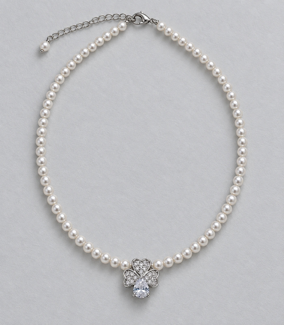 JIMIKI Silver Tone Heart Petal Crystal Drop Pearl Necklace in Silver / White, editorial flat lay
