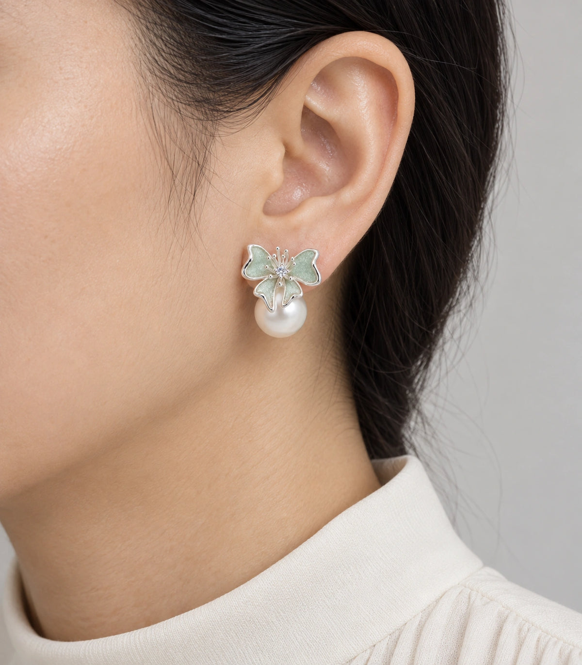 JIMIKI Butterfly Pearl Stud Earring Pair in Silver Tone / Mint, model wearing view #color_silver tone / mint