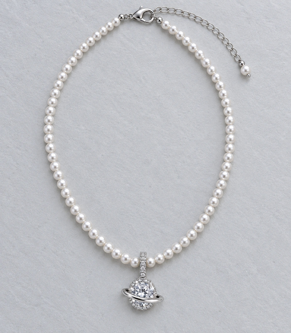 JIMIKI Silver Tone Orbit Crystal Pearl Style Necklace in Silver / White, editorial flat lay