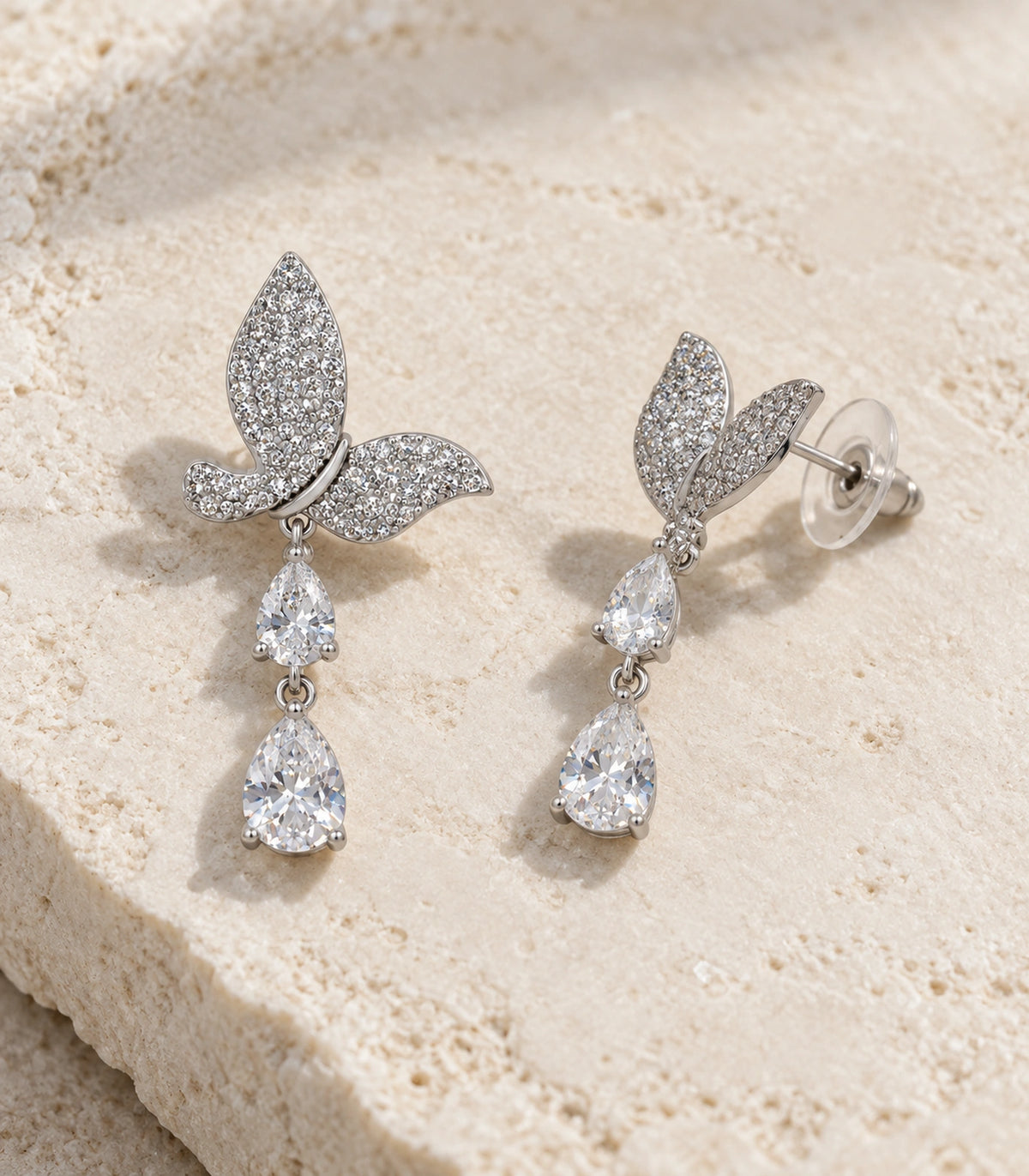 JIMIKI Pave Butterfly Double Teardrop Earring Pair in Silver-tone, editorial flat lay #color_silver-tone