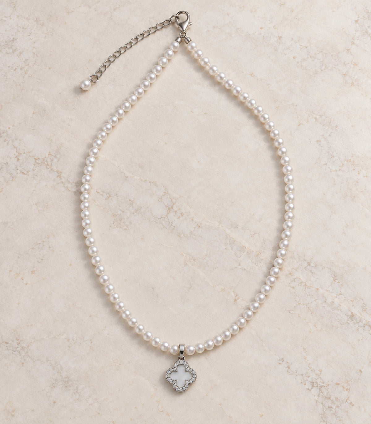 JIMIKI Silver-Tone Pavé Clover Pearl Necklace in Silver-tone / clear / white, arranged in an editorial flat lay