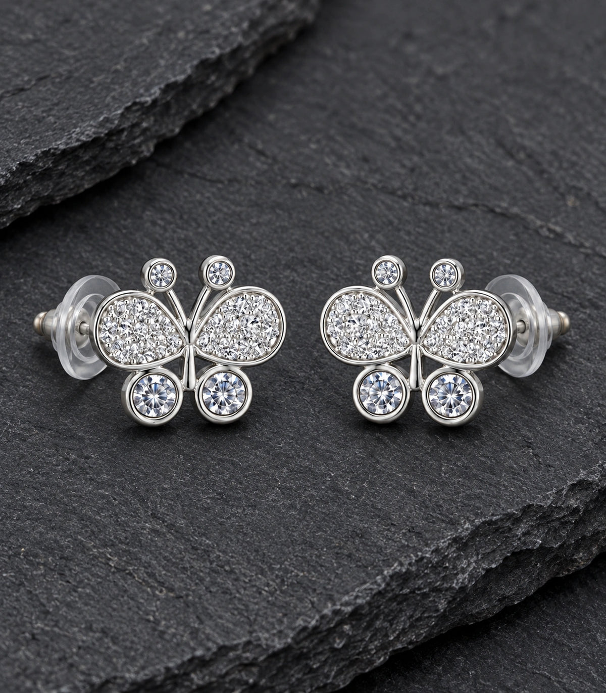 JIMIKI Silver-Tone Pave Crystal Butterfly Stud Earrings in Silver Tone, editorial flat lay