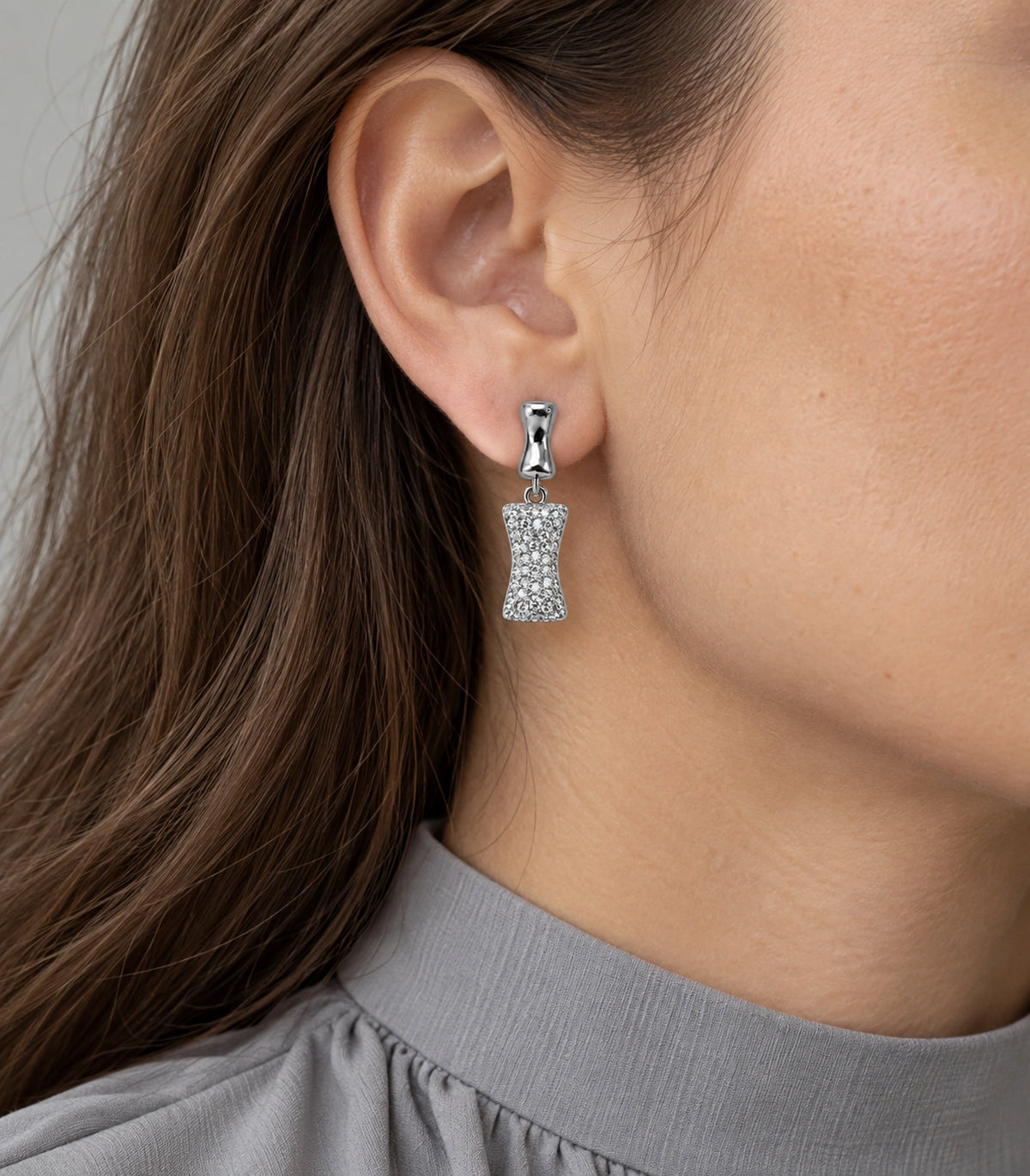 JIMIKI Pave Hourglass Drop Earring Pair in Silver tone, model wearing view #color_silver tone