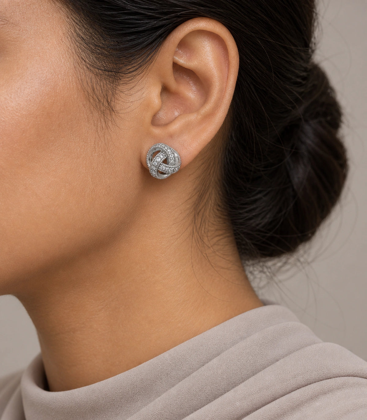 JIMIKI Silver-Tone Pavé Interwoven Knot Stud Earrings in Silver / Clear, model wearing view