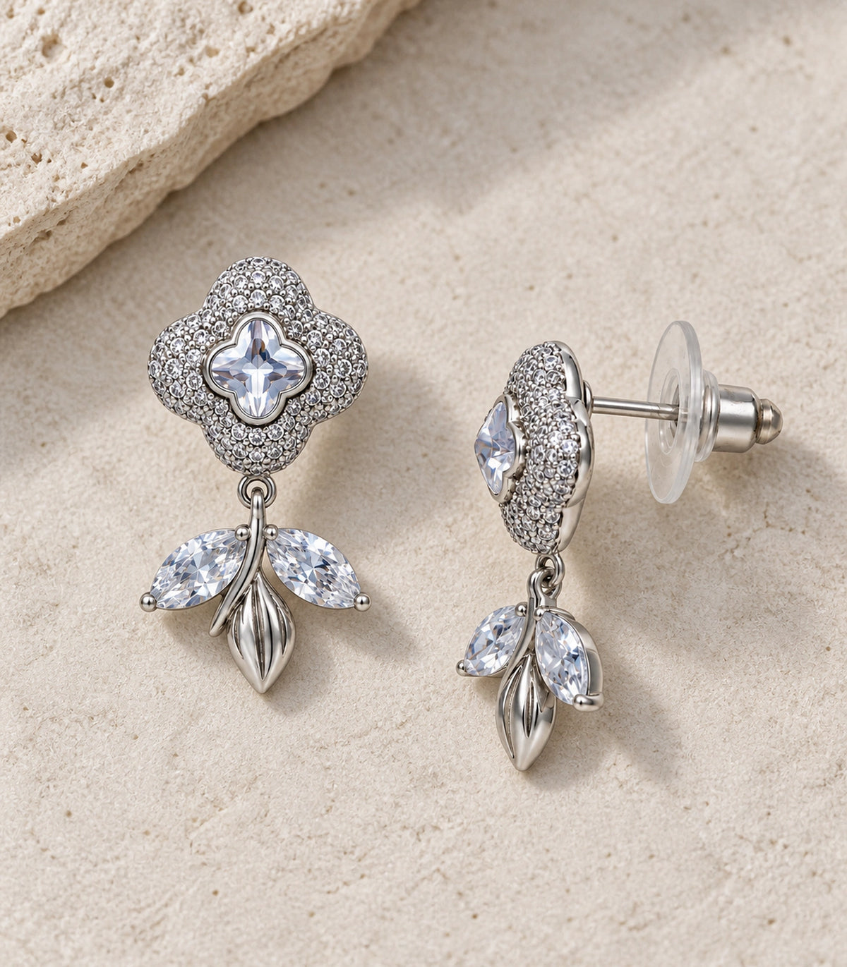 JIMIKI Quatrefoil Crystal Leaf Drop Earring Pair in Silver Tone, editorial flat lay #color_silver tone