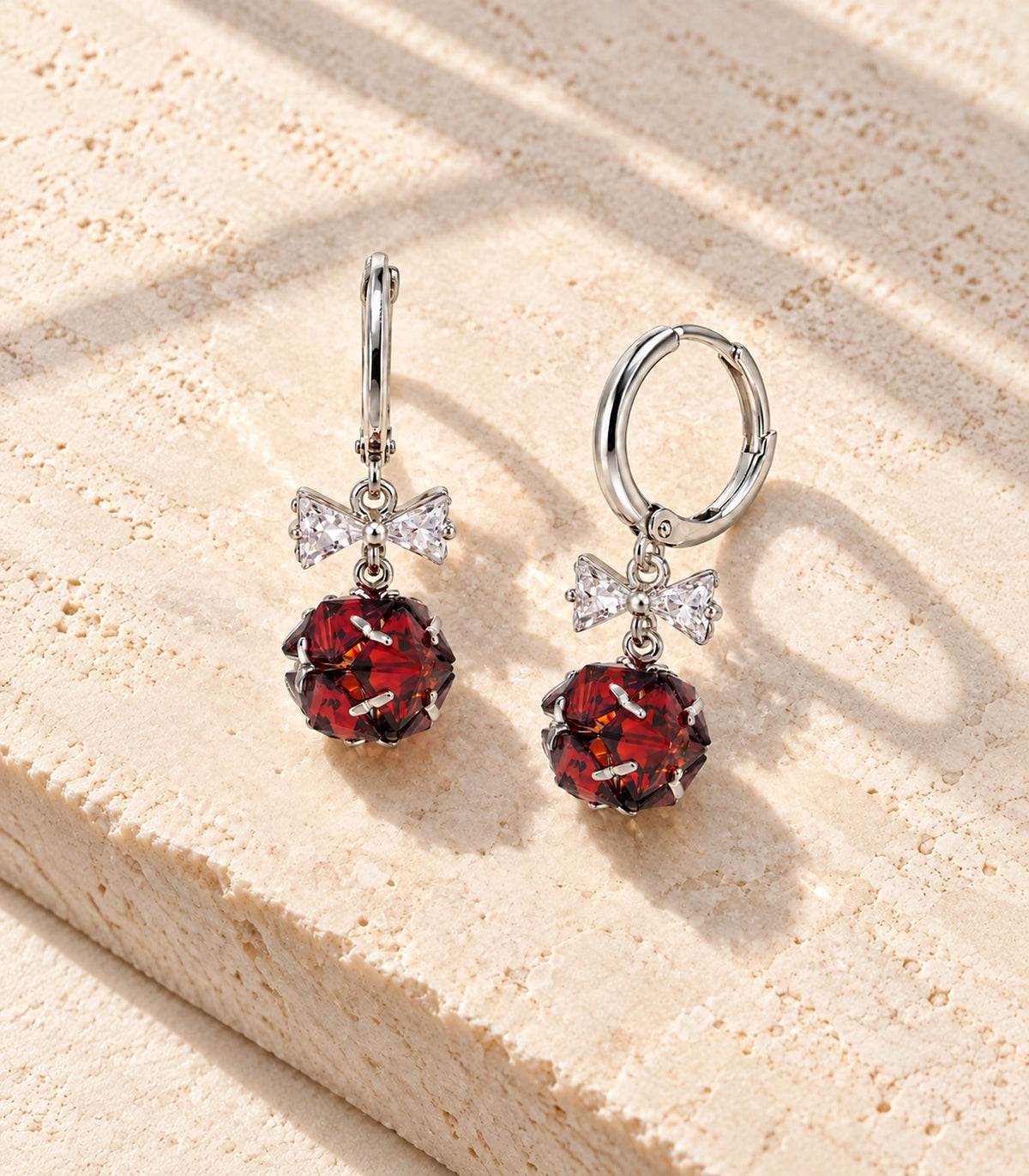JIMIKI Silver Tone Red Crystal Ball Bow Drop Hoop Earring Pair in Silver-tone / Red, editorial flat lay