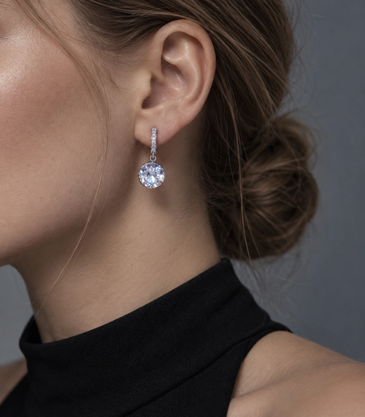 JIMIKI Silver-Tone Round Solitaire Drop Huggie Earrings in Silver / Clear, editorial model view