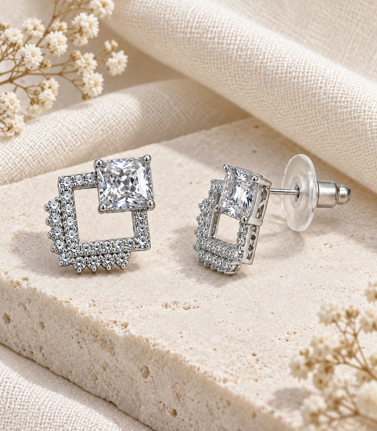 JIMIKI Silver Tone Square Crystal Open Square Stud Earring Pair in Silver tone / clear, editorial flat lay