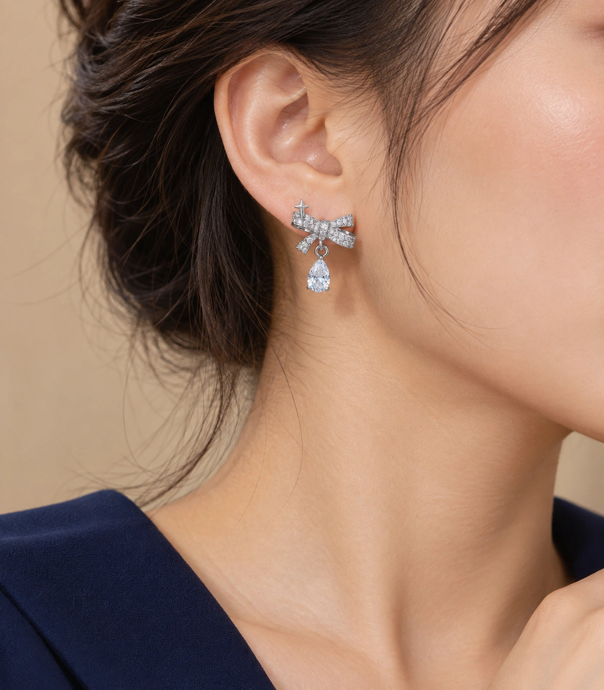 JIMIKI Silver-Tone Star Bow Pear-Drop Earrings in Silver / Clear, editorial model view