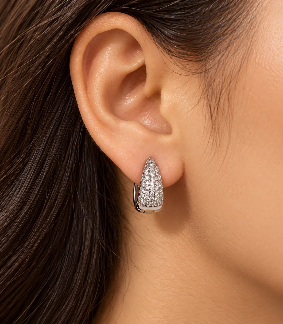 JIMIKI Silver tapered pave huggie hoop earrings, worn in warm editorial lighting #color_silver