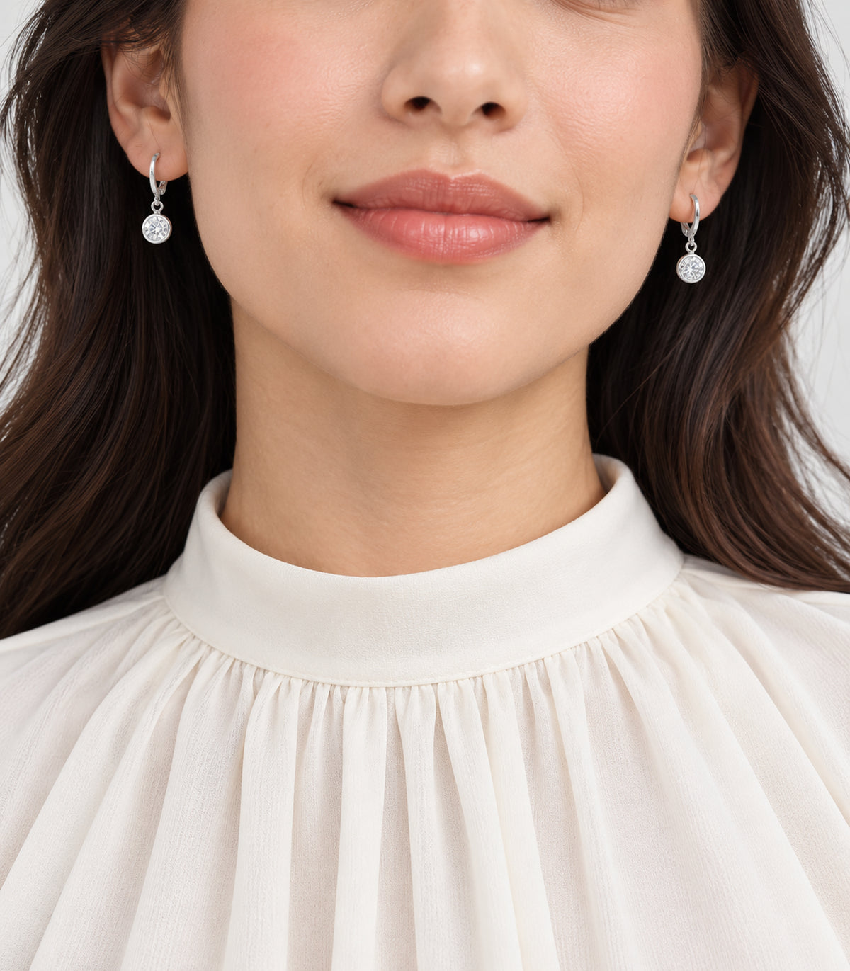 Silver-tone crystal hoop earrings worn in a model view
