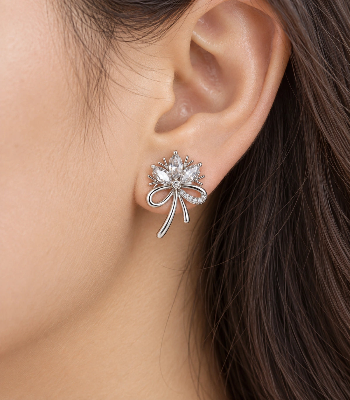 JIMIKI Silver-Tone Three-Petal Crystal Flower Bow Stud Earrings in Silver / Clear, close-up detail