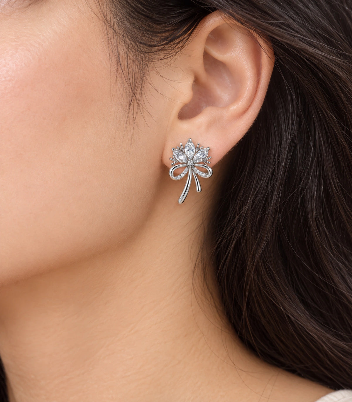 JIMIKI Silver-Tone Three-Petal Crystal Flower Bow Stud Earrings in Silver / Clear, model wearing view