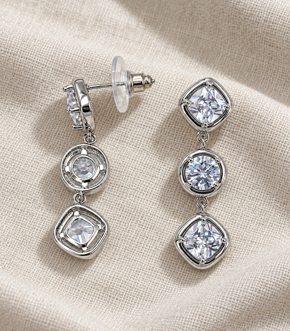 JIMIKI Three Stone Crystal Drop Earring Pair in Silver tone, editorial flat lay #color_silver tone