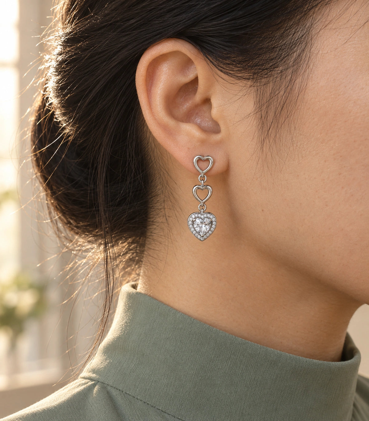 JIMIKI Triple Heart Crystal Drop Earring Pair in Silver tone / clear, editorial model view #color_silver tone / clear