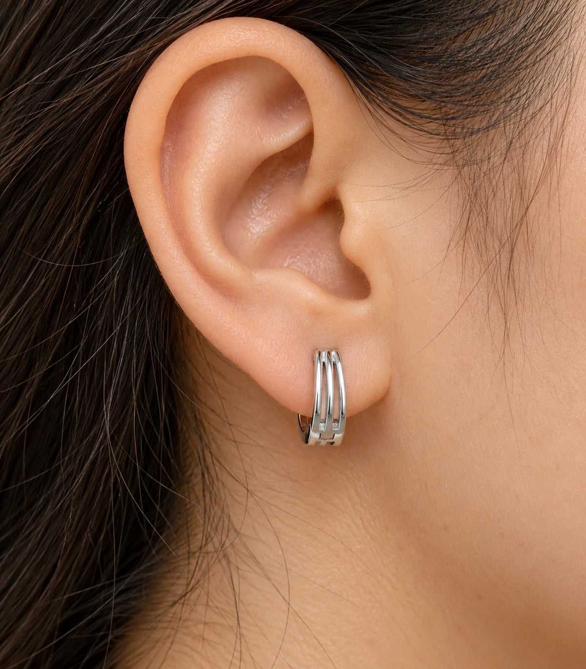 JIMIKI Silver Triple Open Rail Huggie Hoop Earrings, worn closeup showing front details #color_silver