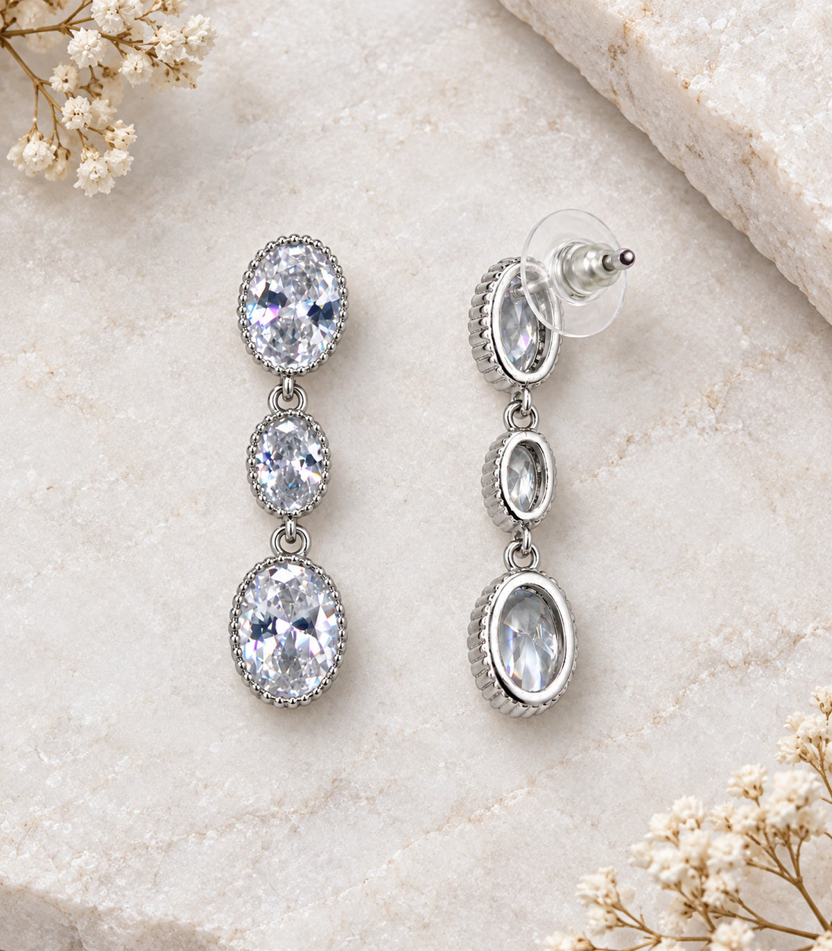JIMIKI Triple Oval Crystal Drop Earrings in Silver tone, editorial flat lay #color_silver tone