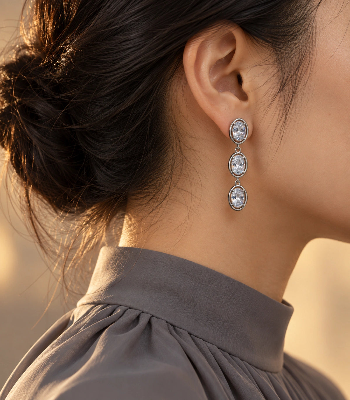 JIMIKI Triple Oval Crystal Drop Earring Pair in Silver tone, editorial model view #color_silver tone
