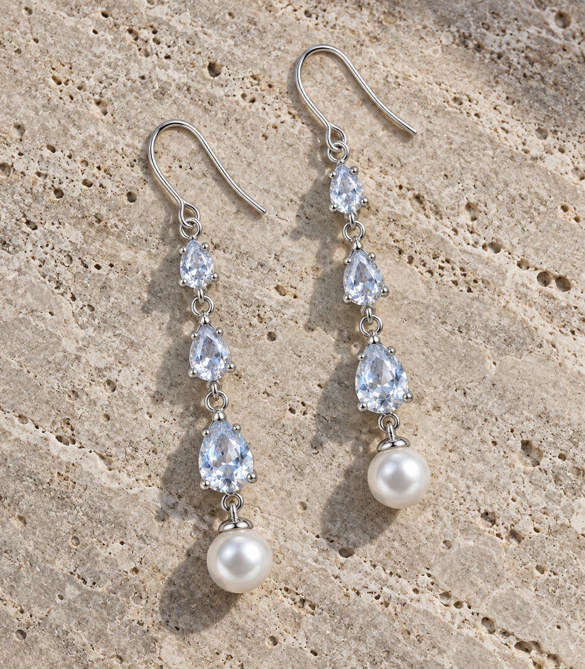 JIMIKI Silver-Tone Triple Pear Crystal Pearl Drop Earrings in Silver Tone, editorial flat lay