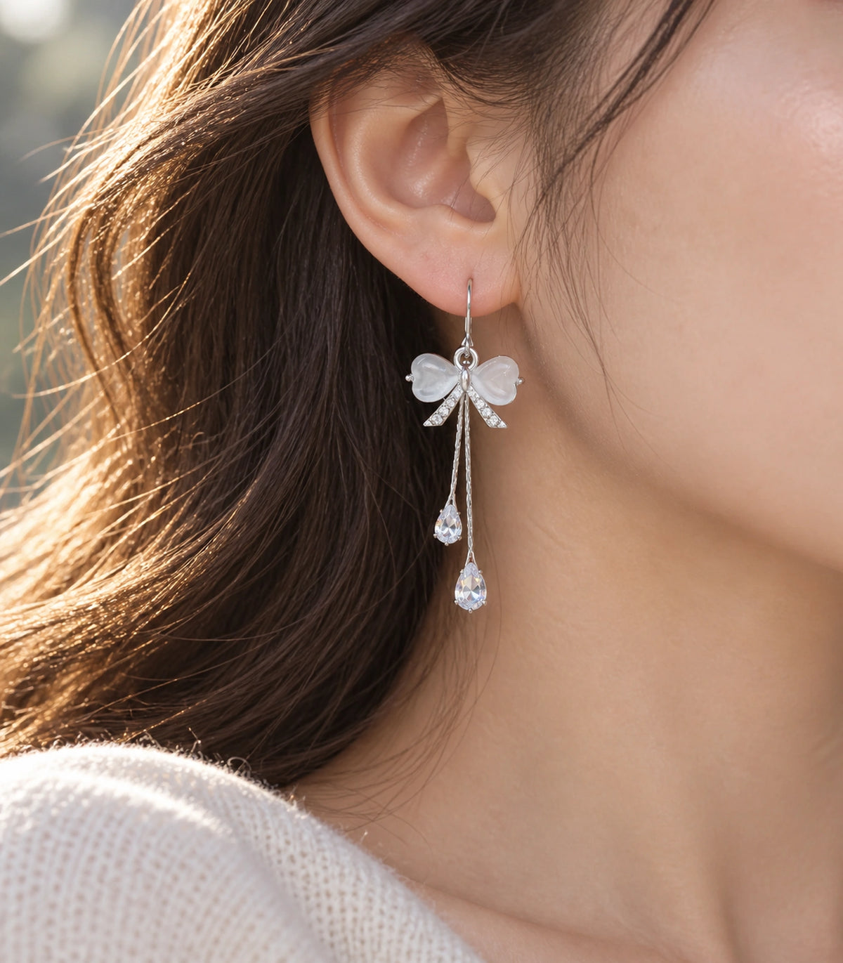 JIMIKI Silver Tone White Bow Twin Pear Chain Earring Pair in Silver-tone, editorial model view