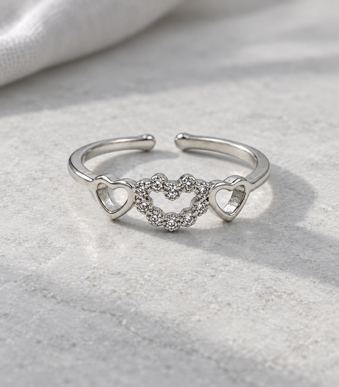 JIMIKI Triple Heart Crystal Adjustable Ring in Silver - editorial flatlay #color_silver