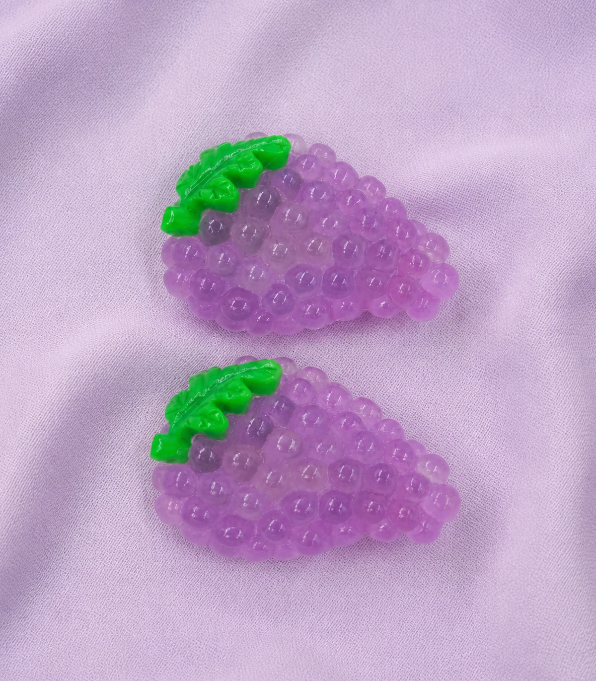 Triangular Grape Barrette Pair editorial flat lay