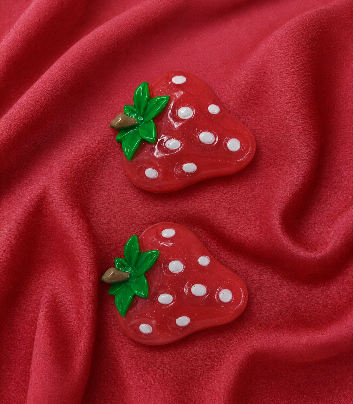 White Seed Strawberry Barrette Pair editorial flat lay