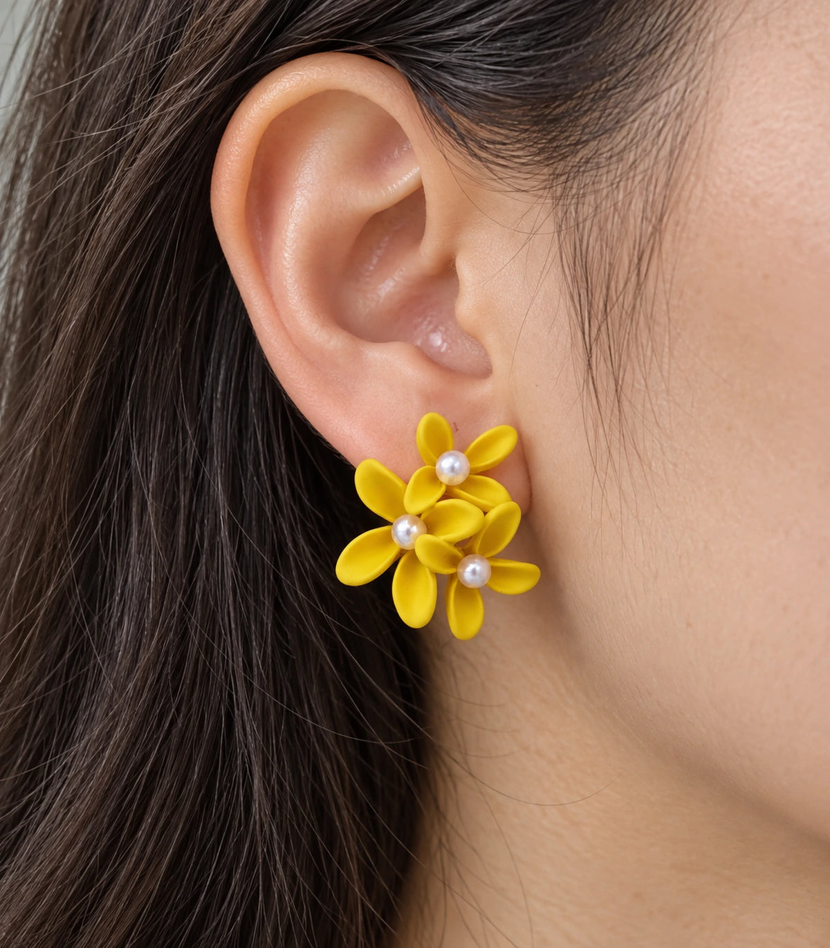JIMIKI Yellow cascading floral cluster stud earrings, close-up of the three pearl-like centres and curved petals #color_yellow