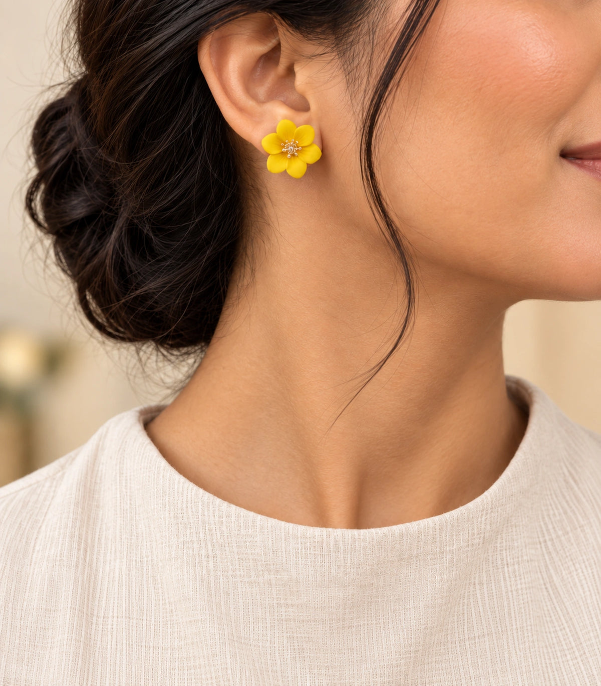 JIMIKI Yellow compact six petal flower stud earrings, styled portrait showing the flower stud at the ear #color_yellow