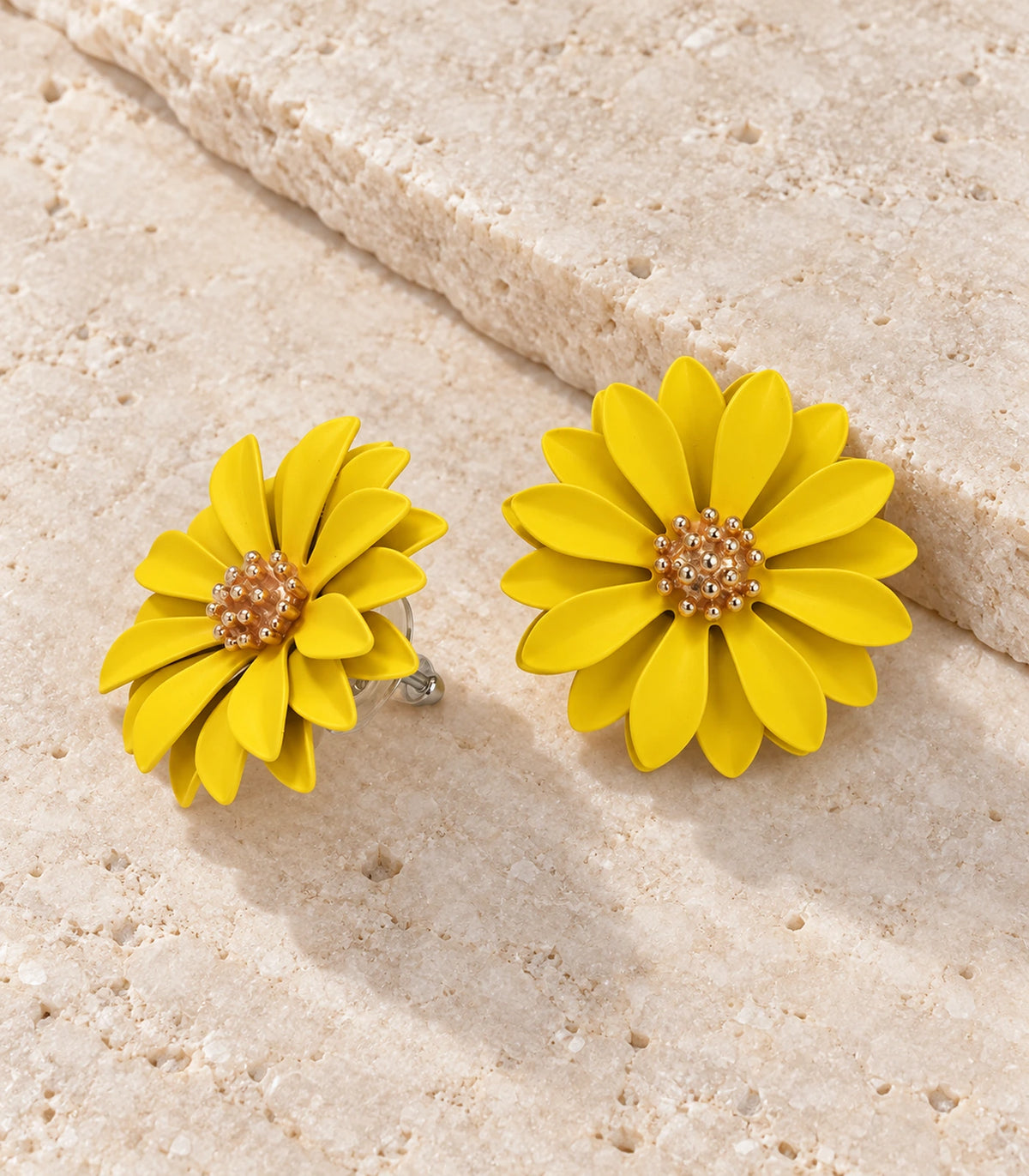 JIMIKI Yellow layered starburst daisy stud earrings, matching pair in a styled flat lay #color_yellow